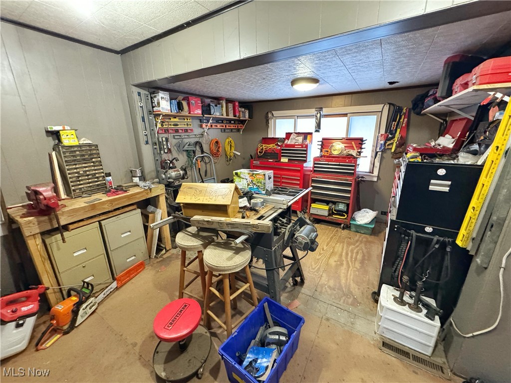 72117 Barton Road Bridgeport, OH 43912 - Photo 27 of 42 Miscellaneous room featuring a workshop area, wooden walls, and concrete flooring