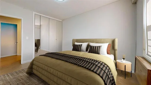 a bedroom with a bed and wooden floor