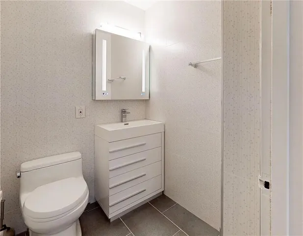 a bathroom with a toilet sink and mirror