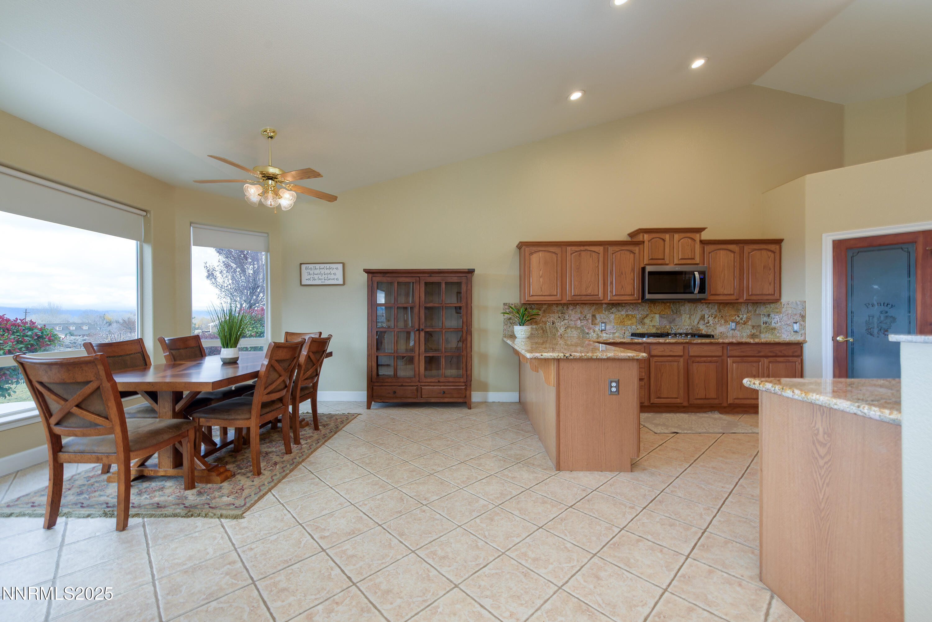 1572 Sawmill Road Gardnerville, NV 89410 - Photo 12 of 43 a kitchen with stainless steel appliances kitchen island granite countertop a table chairs and a refrigerator