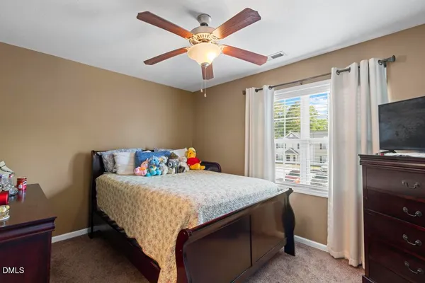 a bedroom with a bed and a tv on the dresser