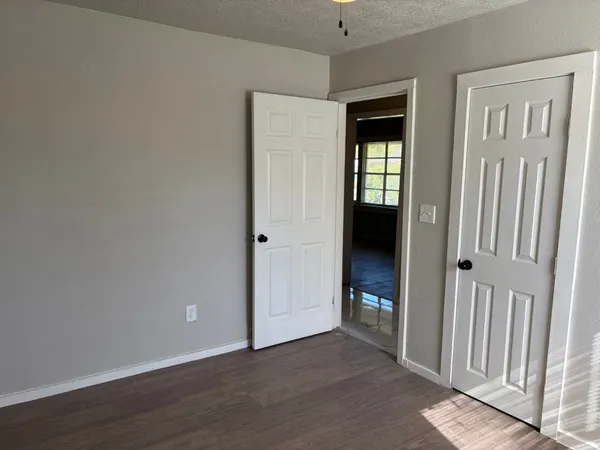 an empty room with wooden floor and a window