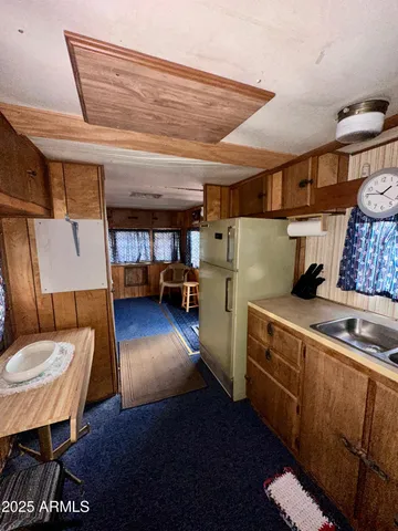 a view of a kitchen with stainless steel appliances wooden floor and a refrigerator