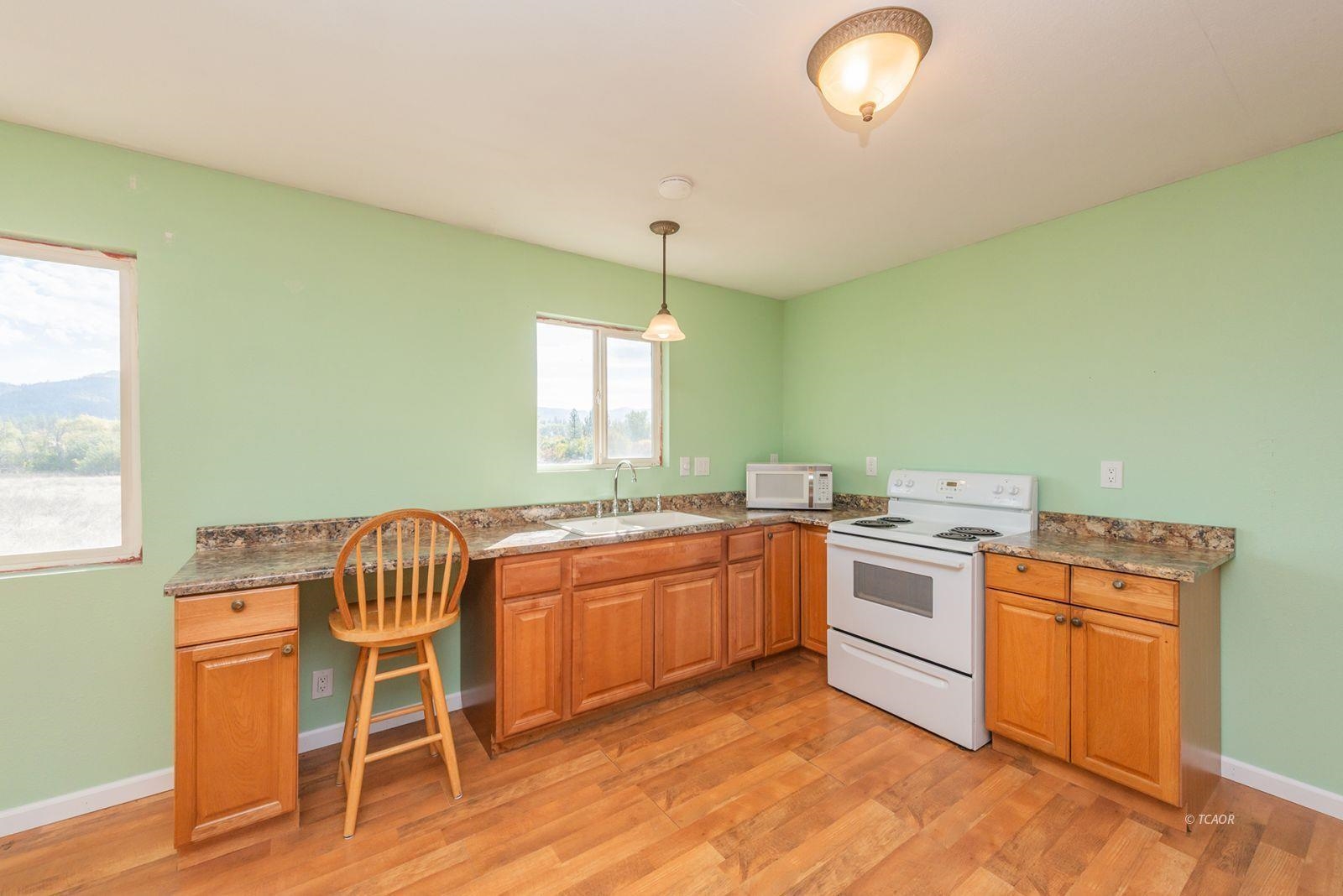 1095 Hyampom Road Hayfork, CA 96041 - Photo 11 of 41 a kitchen with a stove a sink and a refrigerator