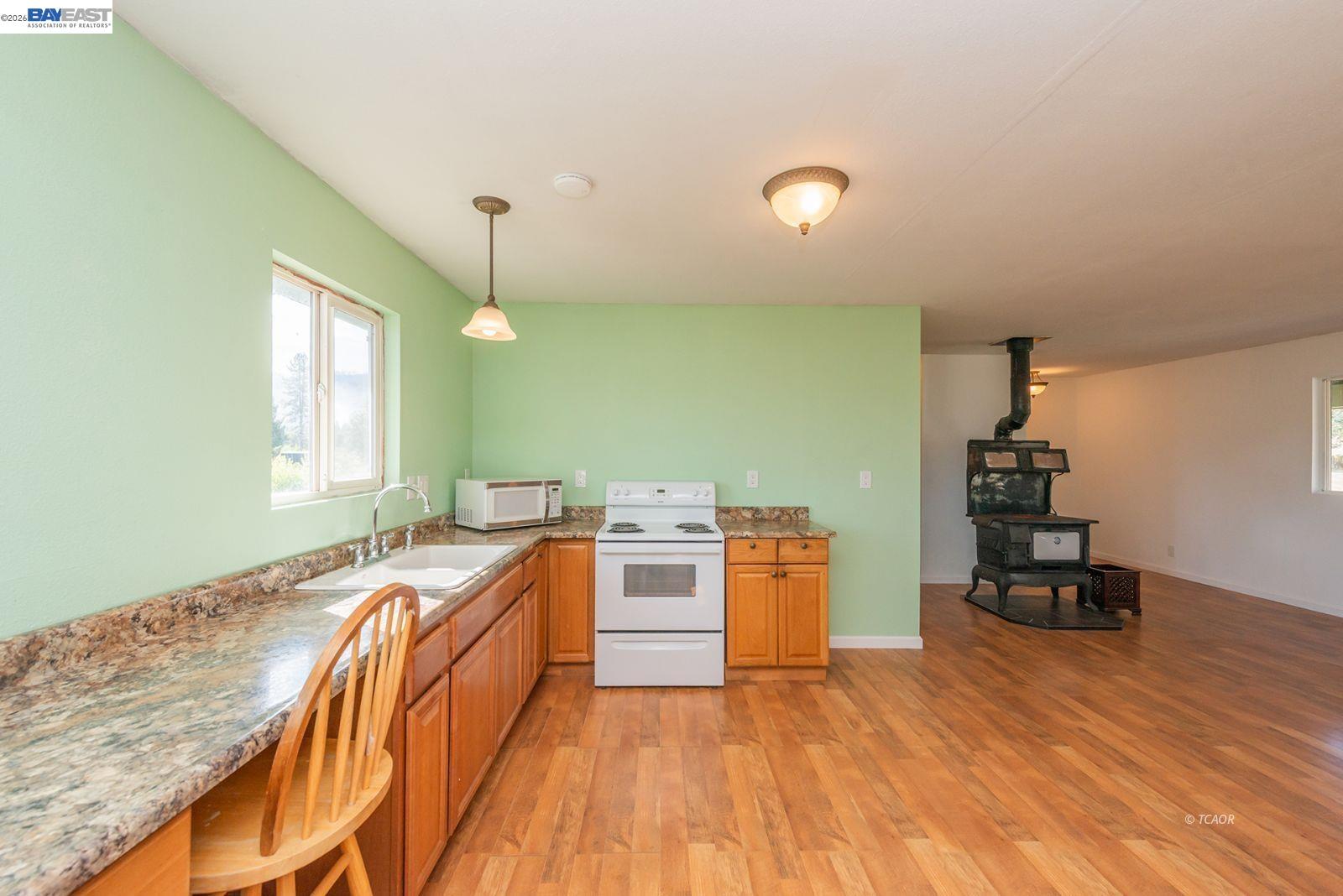 1095 Hyampom Road Hayfork, CA 96041 - Photo 12 of 41 a kitchen with stainless steel appliances granite countertop a sink and stove top oven