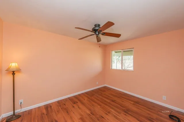 a view of room with a ceiling fan and wooden floor