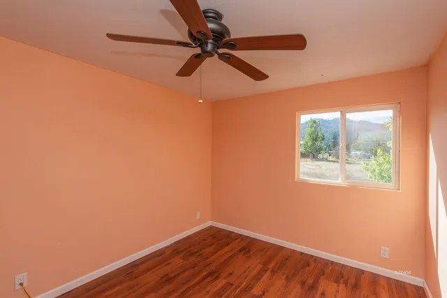 a view of a small space with wooden floor and a window