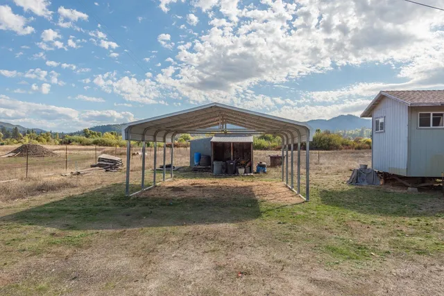 a backyard of a house with table and chairs