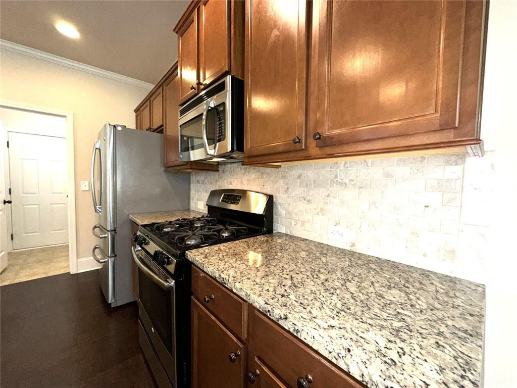 1365 Delo Lane Cumming, GA 30041 - Photo 11 of 43 a kitchen with stainless steel appliances granite countertop a stove a sink and a microwave