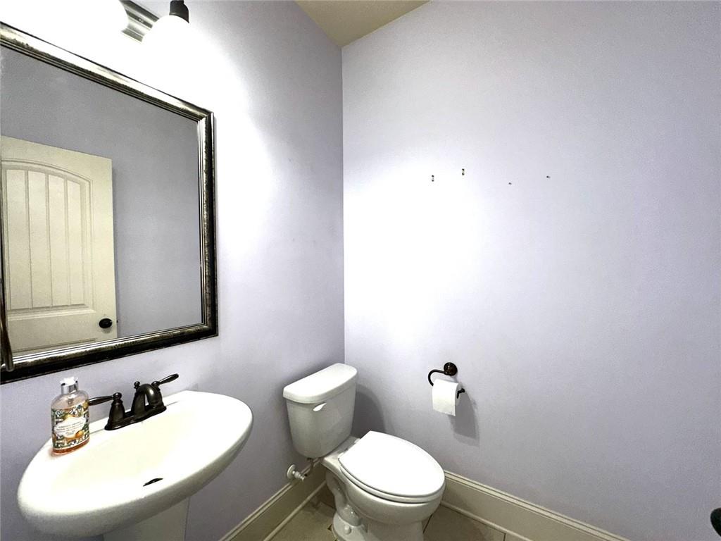 1365 Delo Lane Cumming, GA 30041 - Photo 19 of 43 a bathroom with a toilet a sink and mirror