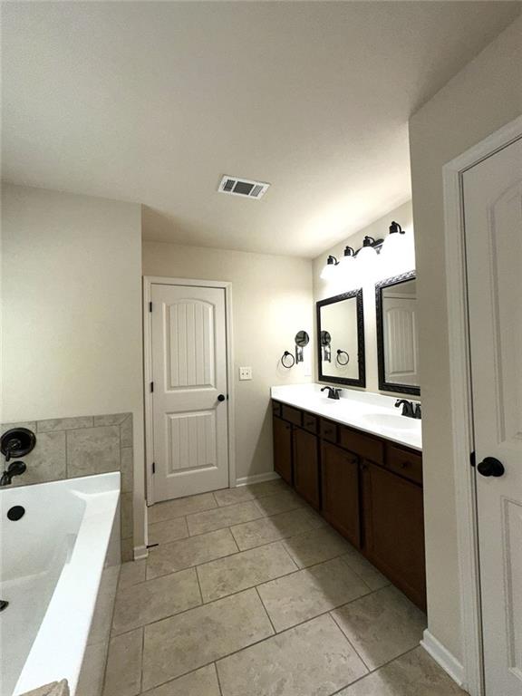 1365 Delo Lane Cumming, GA 30041 - Photo 28 of 43 a large bathroom with a tub sink shower and mirror