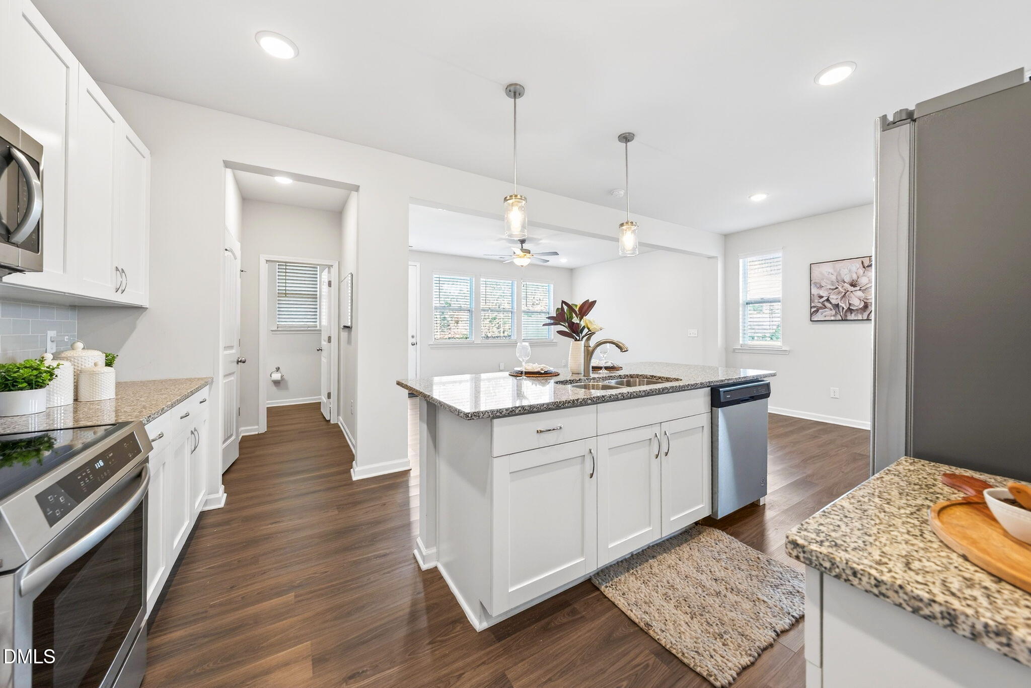211 Kineton Woods Way Garner, NC 27529 - Photo 7 of 18 a large kitchen with kitchen island granite countertop a sink refrigerator and wooden floor