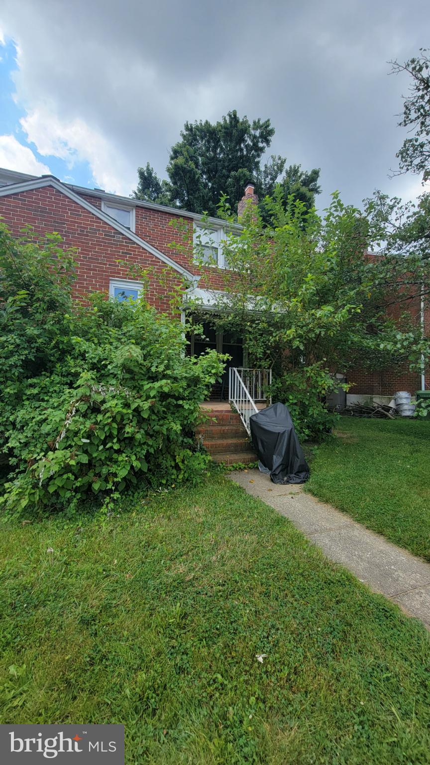 Charming brick home with lush greenery.