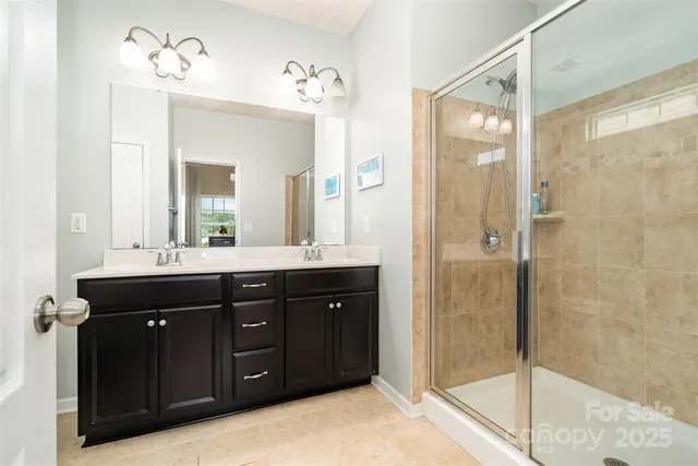 a bathroom with a double vanity sink mirror and shower