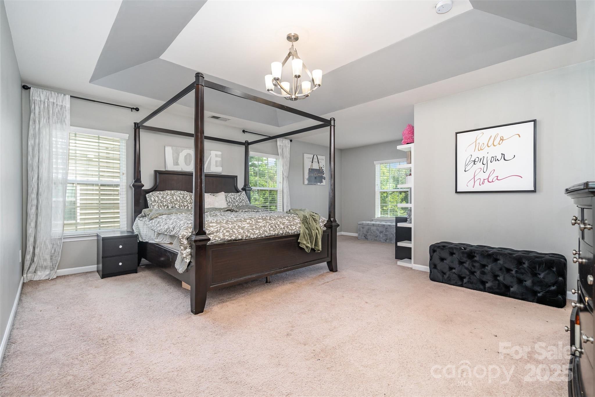 8931 Happiness Road Harrisburg, NC 28075 - Photo 15 of 32 a bedroom with bed and a chandelier