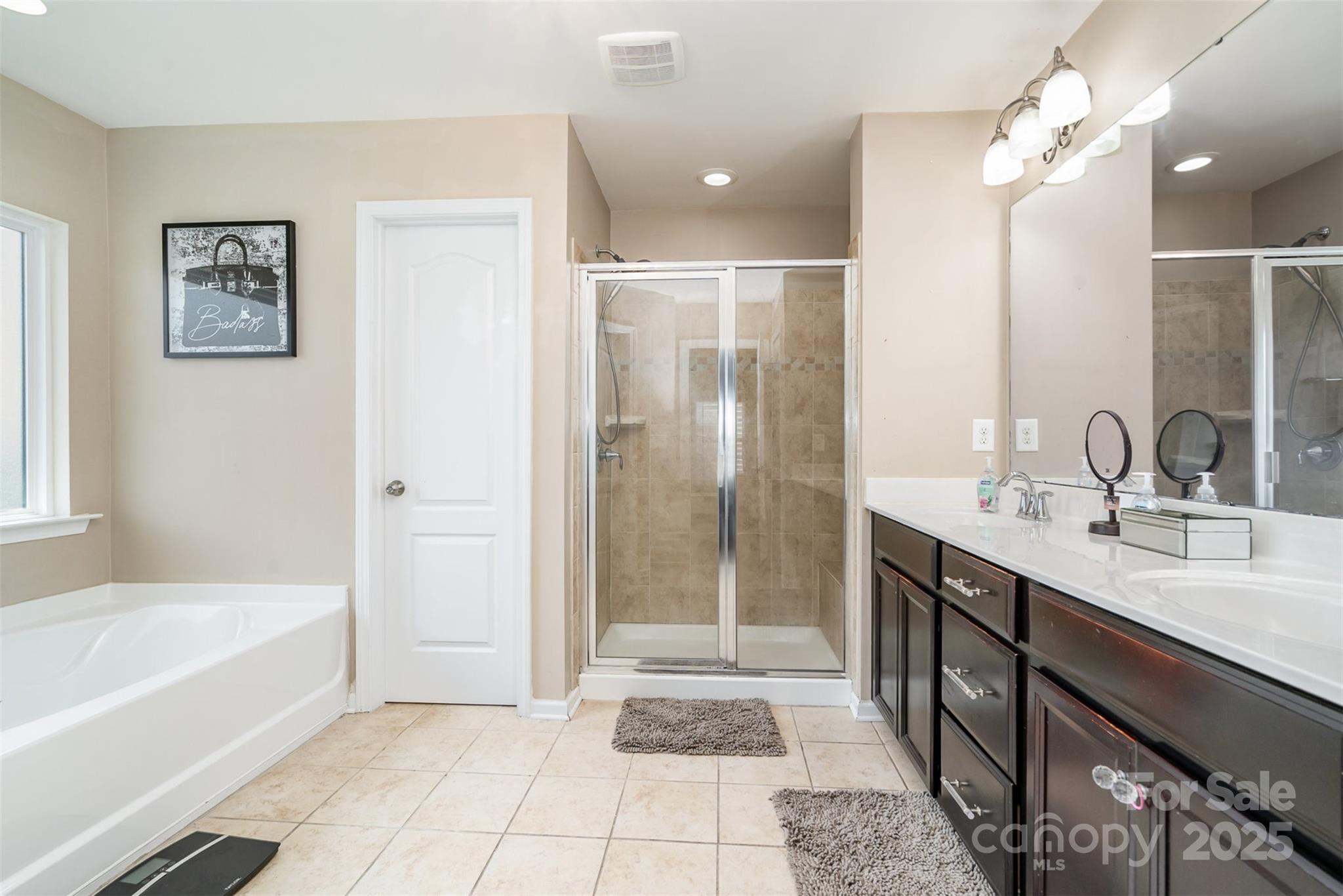 8931 Happiness Road Harrisburg, NC 28075 - Photo 17 of 32 a bathroom with a tub a sink and a mirror