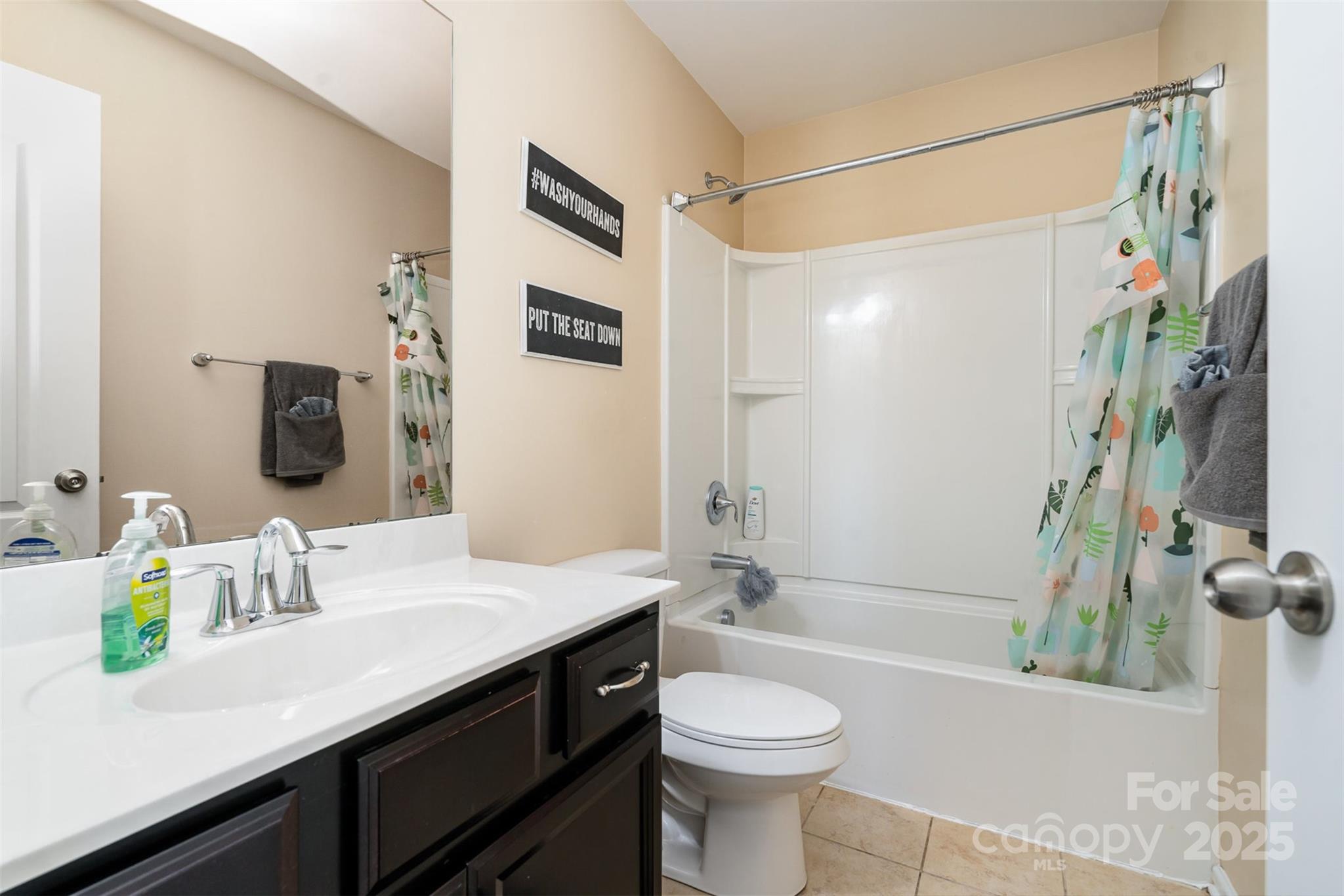 8931 Happiness Road Harrisburg, NC 28075 - Photo 20 of 32 a bathroom with a sink a toilet a mirror a bathtub and shower