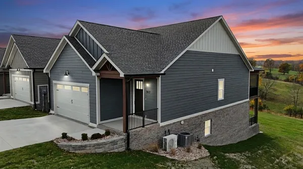 a view of a house with a small yard and floor to ceiling window