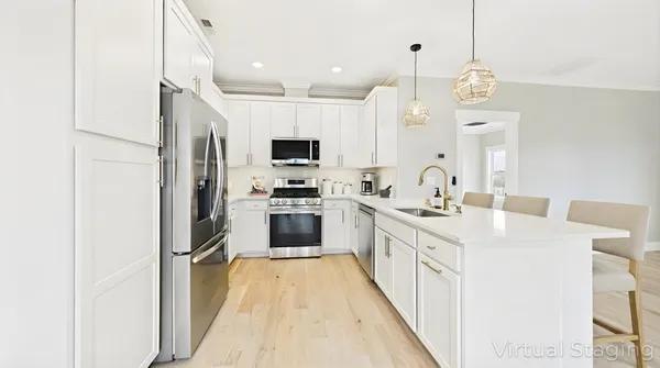 a kitchen with kitchen island a sink appliances and cabinets