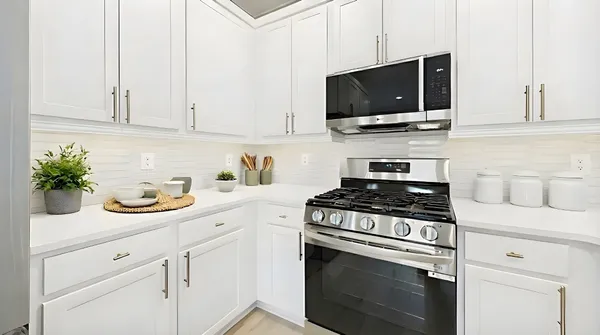 a kitchen with white cabinets and appliances