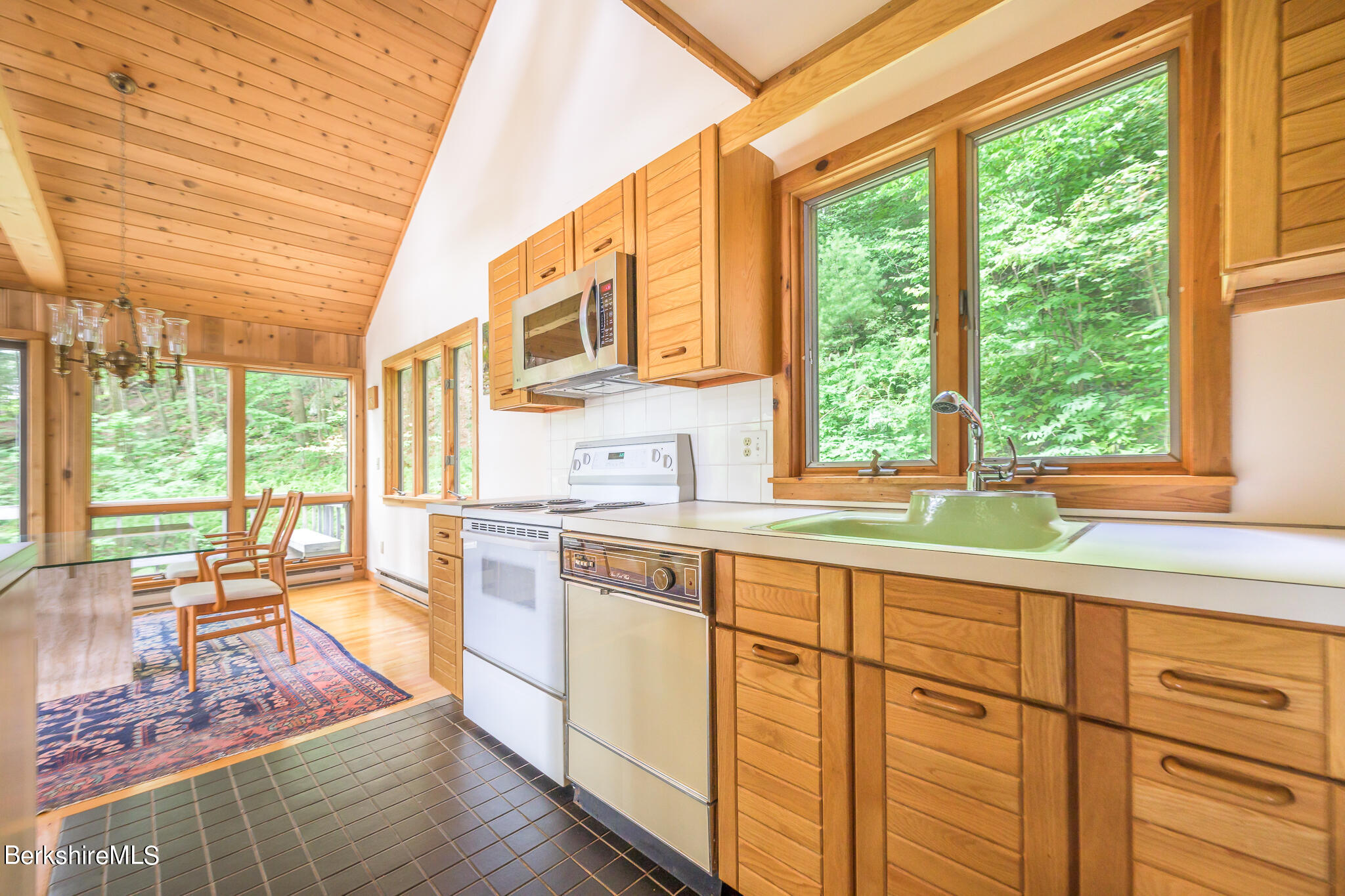 29 Lakeside Drive Tyringham, MA 01238 - Photo 14 of 31 a spacious kitchen with stainless steel appliances granite countertop a stove a sink and white cabinets with wooden floor