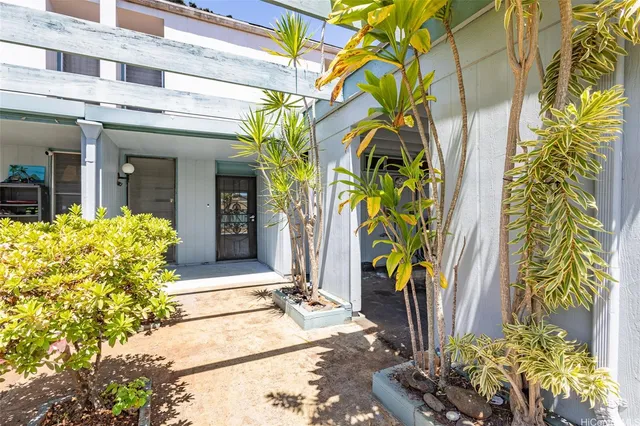 a view of yellow house with potted plants