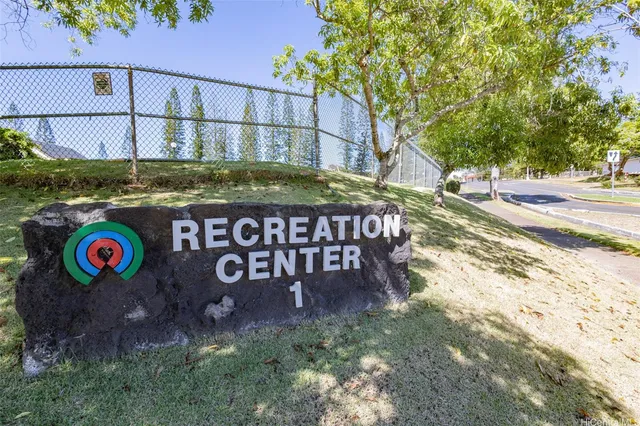 a view of a street sign under a large tree