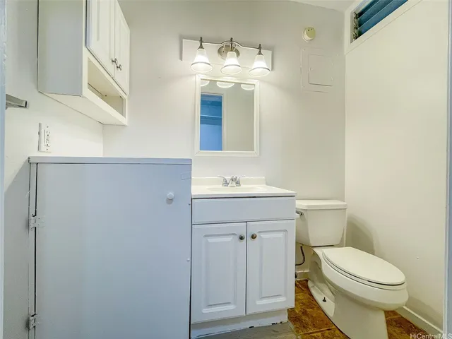 a bathroom with a toilet a sink and mirror