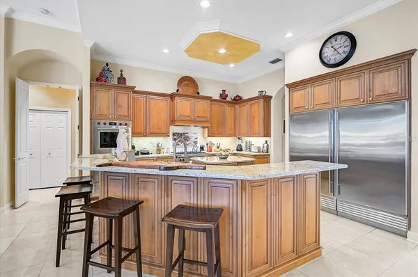 a kitchen with stainless steel appliances granite countertop a stove a sink dishwasher and a refrigerator with wooden floor