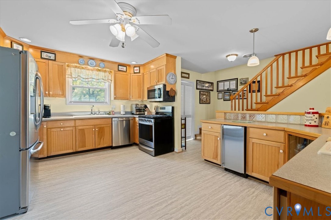 683 Villa Road Claremont, VA 23881 - Photo 11 of 28 a kitchen with stainless steel appliances granite countertop a stove a sink dishwasher a refrigerator and white cabinets with wooden floor