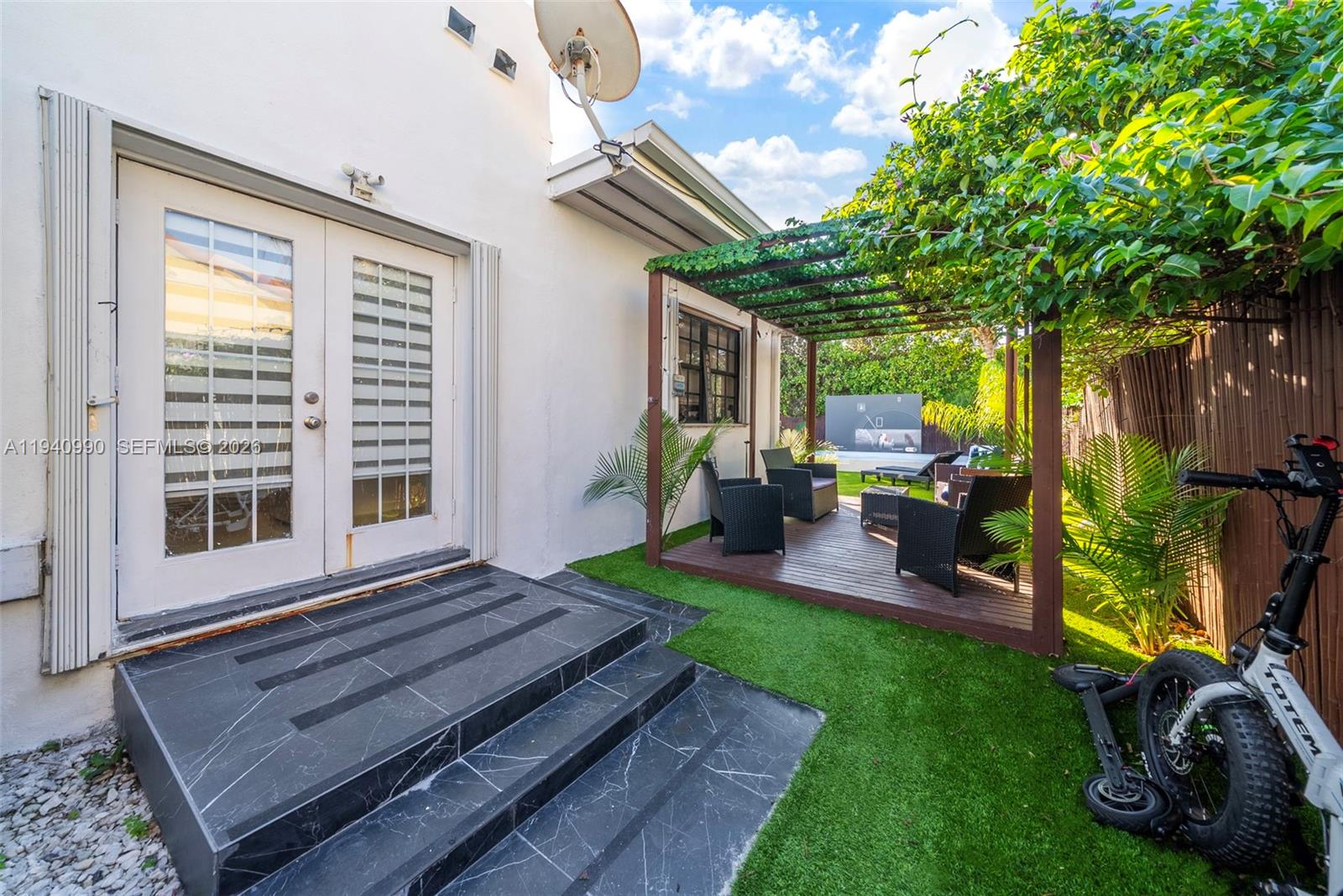 8918 Harding Avenue Surfside, FL 33154 - Photo 3 of 24 a view of a backyard with plants and a patio