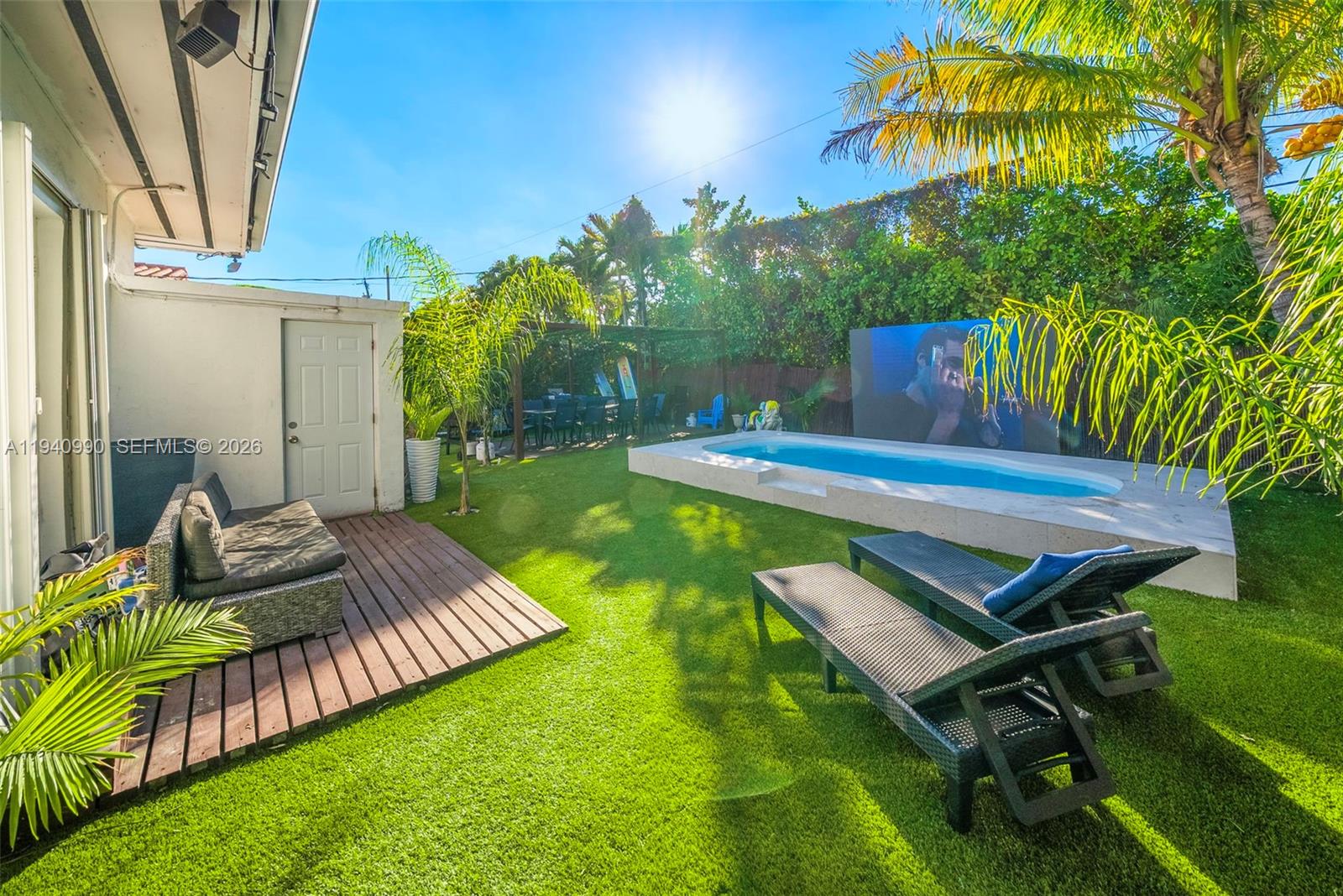 8918 Harding Avenue Surfside, FL 33154 - Photo 4 of 24 a view of a backyard with couches chairs and a table and chairs
