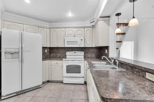 a kitchen with cabinets and white appliances