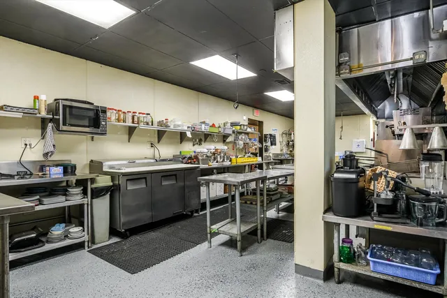 a kitchen with stainless steel appliances kitchen island granite countertop a stove a sink and a microwave