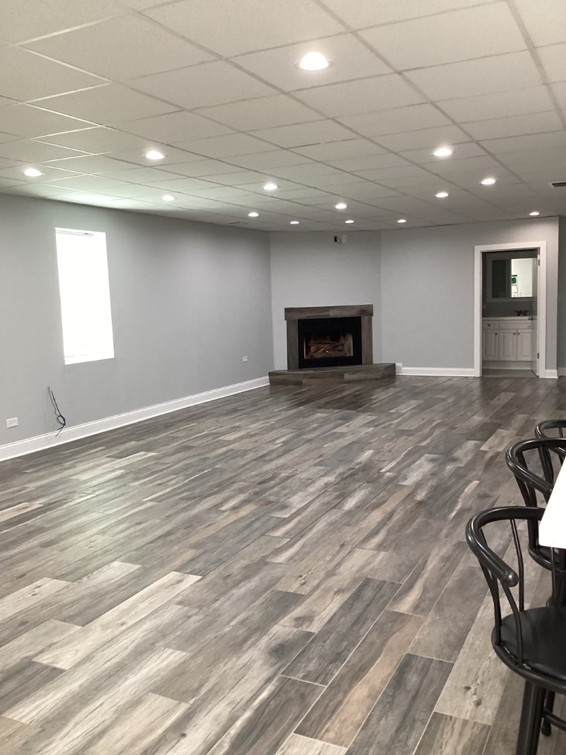 5481 North Northwest Highway Chicago, IL 60630 - Photo 37 of 60 an empty room with wooden floor and fireplace