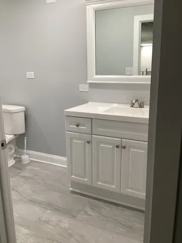 a bathroom with a sink a toilet and mirror