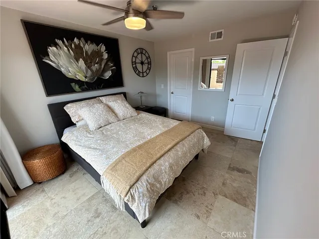 a bedroom with a bed and painting on the wall