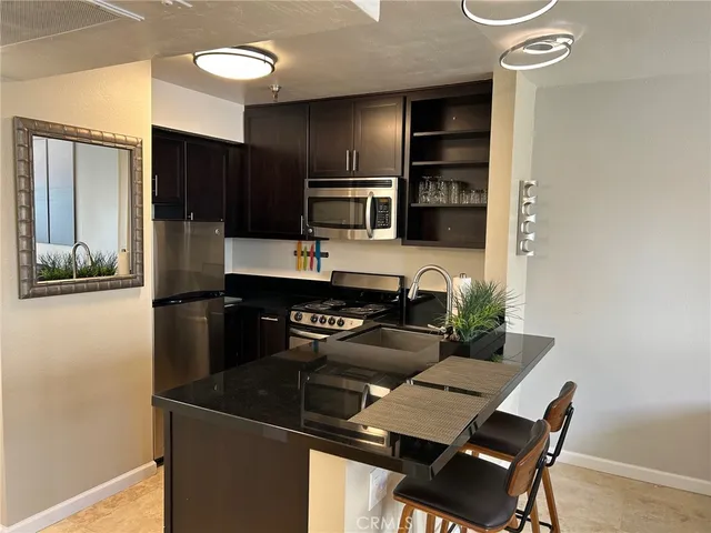 a kitchen with a refrigerator and a stove top oven