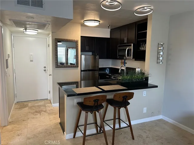 a kitchen with stainless steel appliances granite countertop a sink and a refrigerator