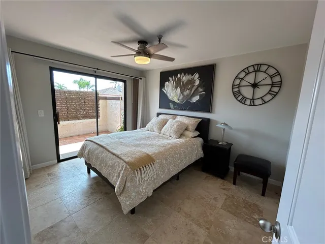 a bedroom with a bed dresser and a large window