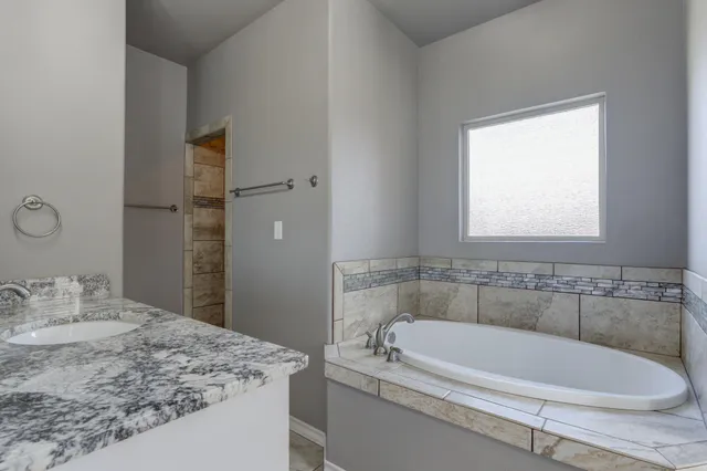 a bathroom with a tub sink and mirror