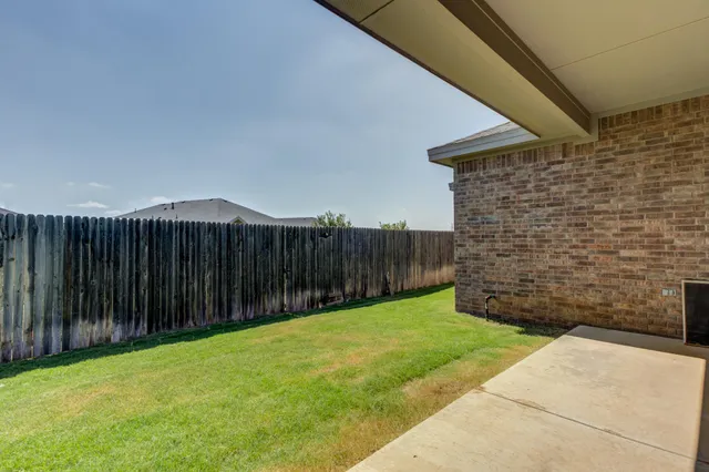 a view of backyard with wooden fence