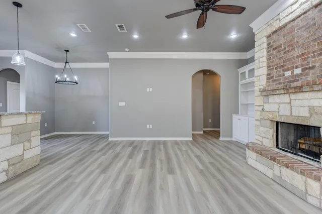 a view of empty room with fireplace and wooden floor