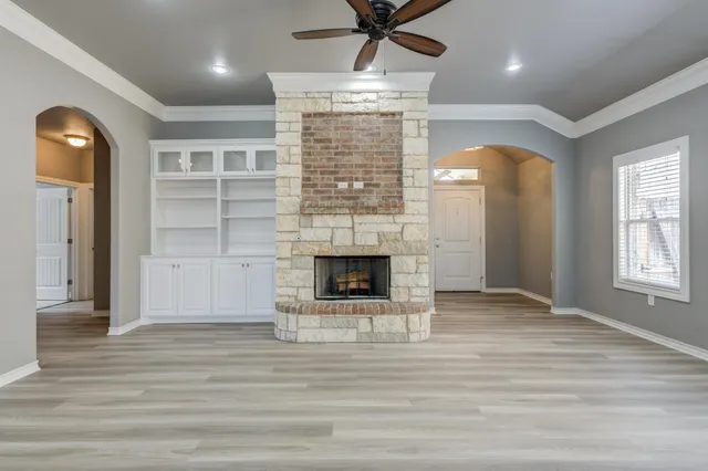 a view of a livingroom with a fireplace window and wooden floor