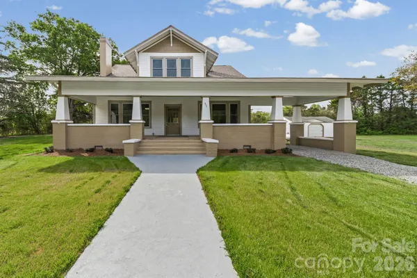 a front view of a house with a garden and yard