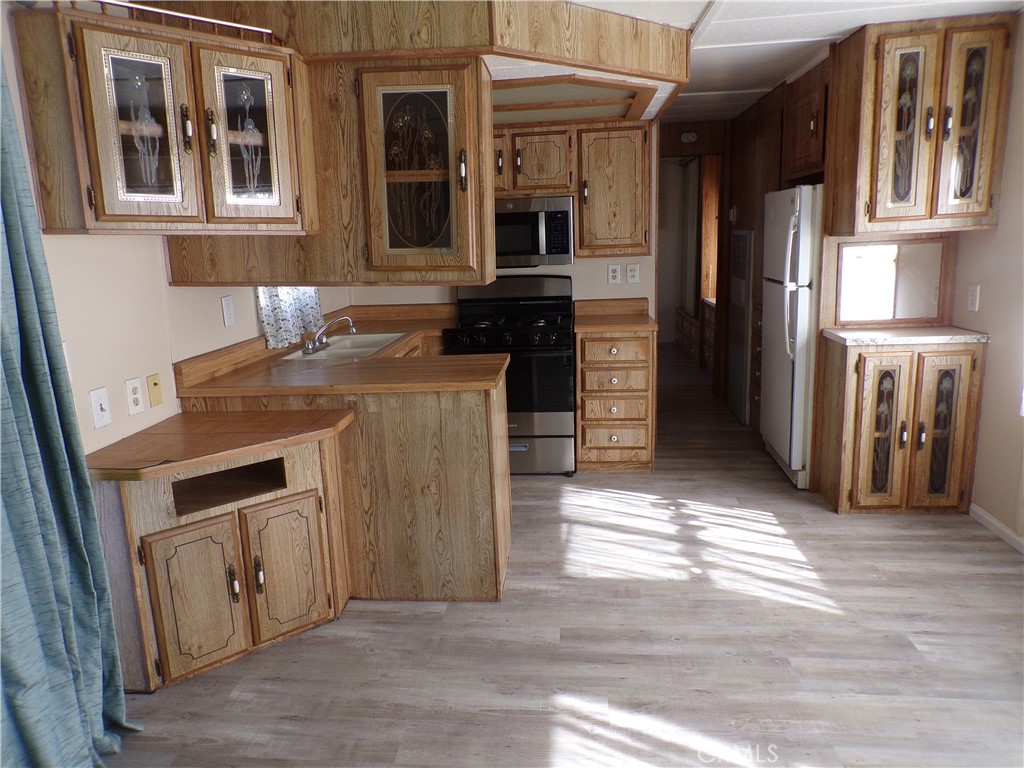 12710 3rd Street, Unit 10 Yucaipa, CA 92399 - Photo 4 of 9 a kitchen with a sink and a refrigerator