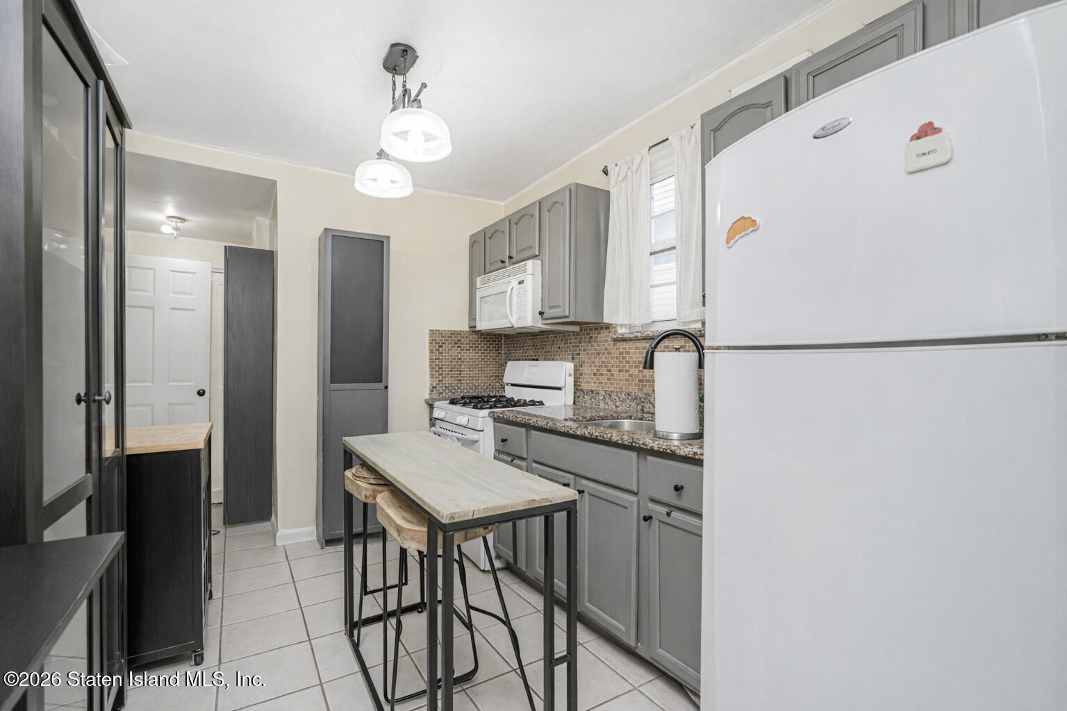 39 Post Lane Staten Island, NY 10303 - Photo 4 of 17 a kitchen with stainless steel appliances a refrigerator a sink a stove a dining table and chairs