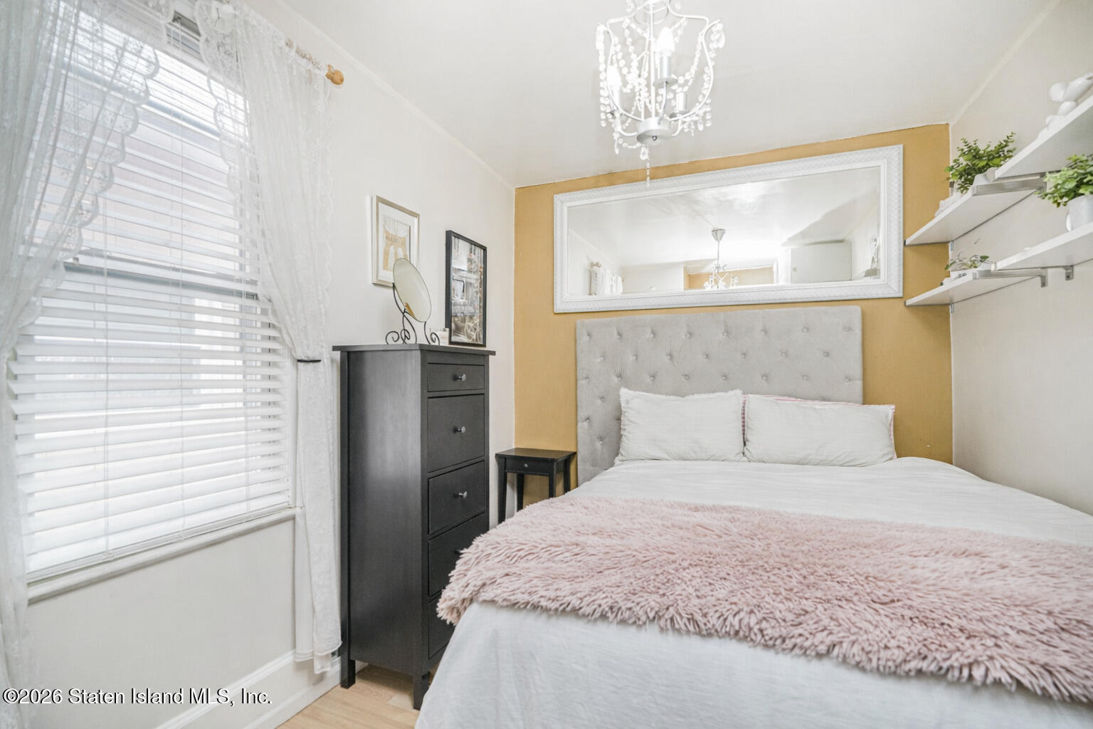 39 Post Lane Staten Island, NY 10303 - Photo 8 of 17 a bedroom with a large bed and chandelier