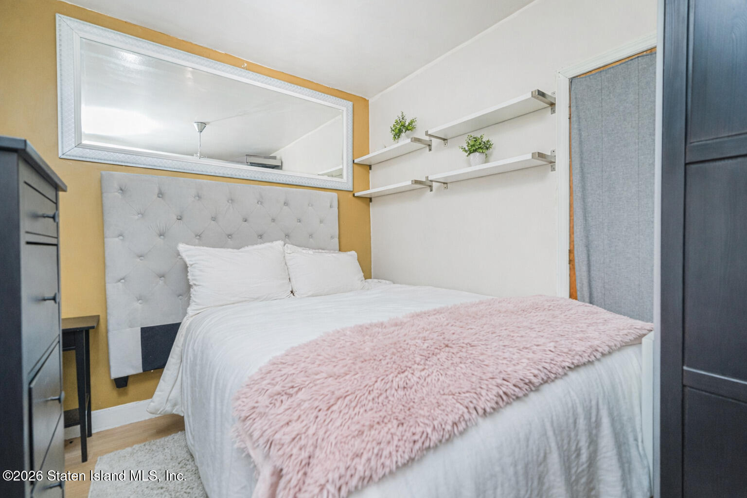 39 Post Lane Staten Island, NY 10303 - Photo 9 of 17 a bedroom with a bed and a mirror on the dresser