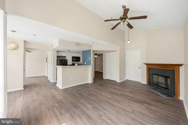 a view of a kitchen and a stove wooden floor a ceiling fan